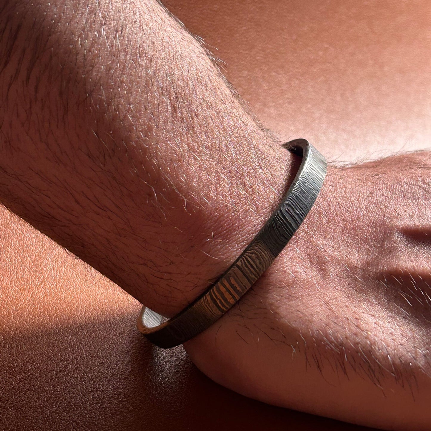 Man wearing damascus cuff under direct light