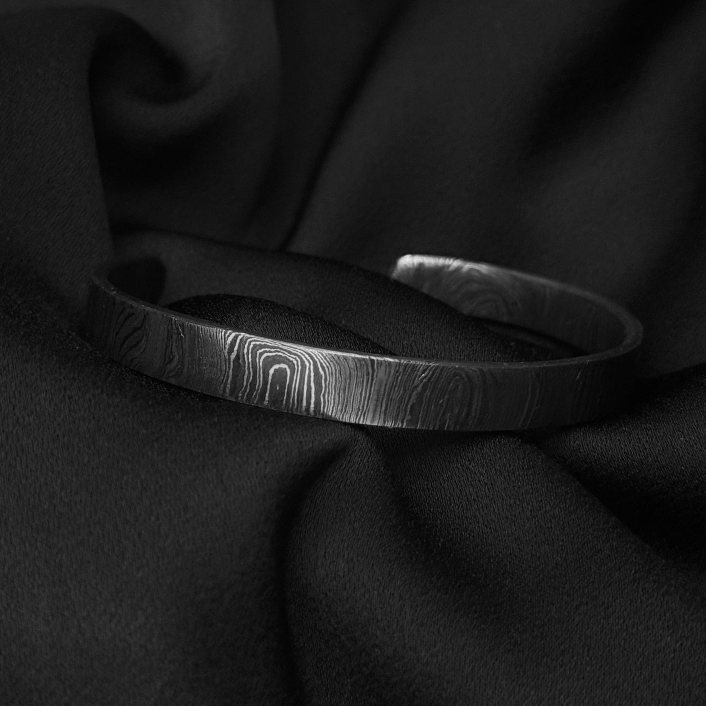 Damascus steel cuff on silk side view
