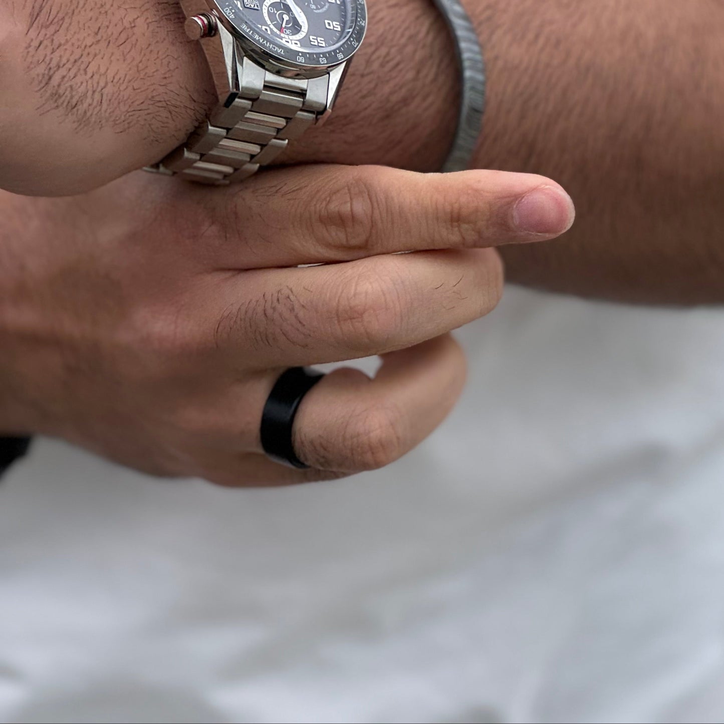 Man wearing bracelet with watch and black ring
