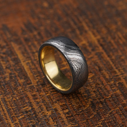 Brass Inlay Damascus steel ring for men against wooden background