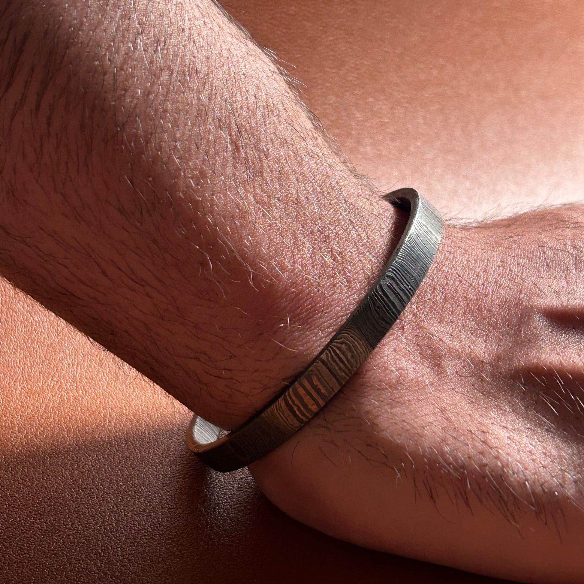 Man wearing damascus cuff under direct light