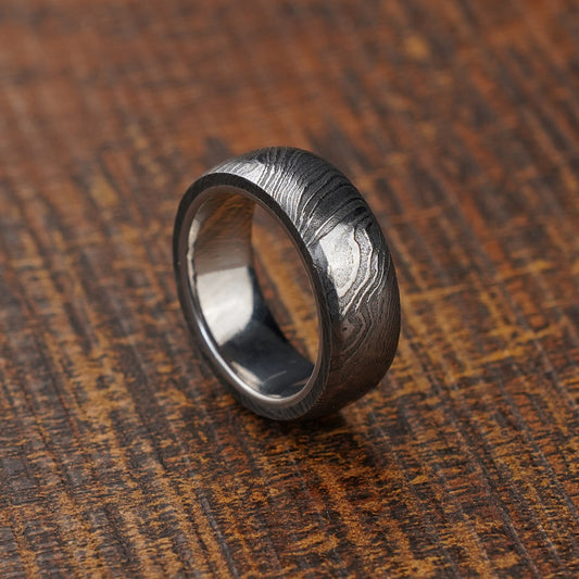luxury gift for men, damascus ring on wooden background
