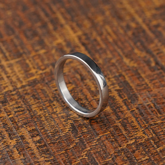 silver ss ring band minimalist against wood background