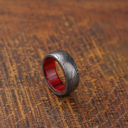 red wood damascus ring on wooden background